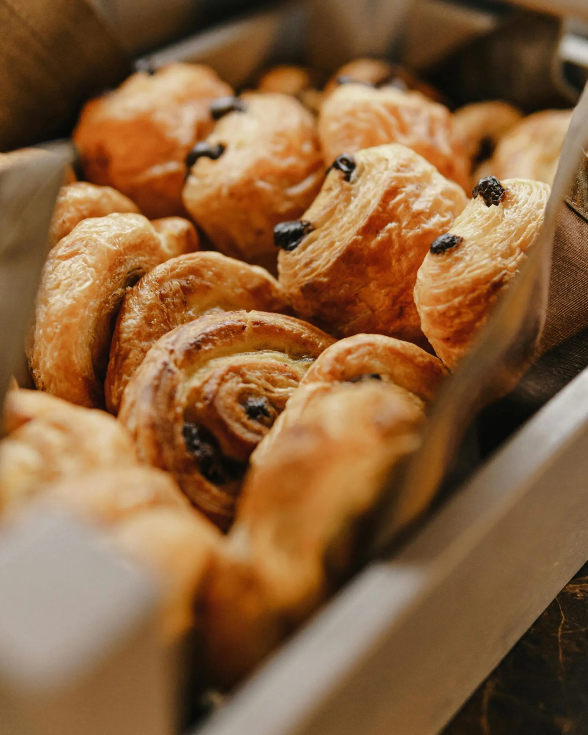 Vassoio con pain au chocolat affiancati, pronti per il buffet della colazione.