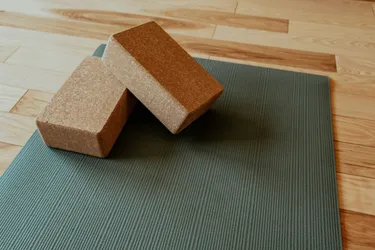 Green yoga mat with two yoga blocks placed on top.