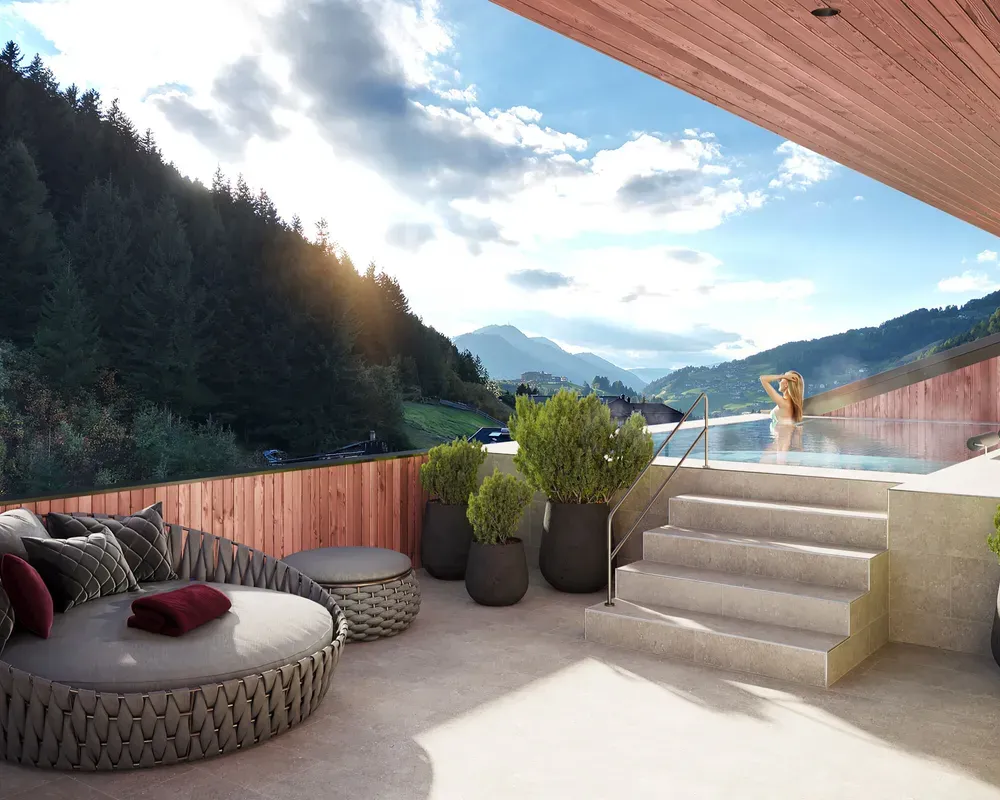 Rooftop whirlpool at Hotel Oswald in Selva di Val Gardena, surrounded by the majestic Dolomites on a bright sunny day, with a cozy round sofa nearby for outdoor relaxation.