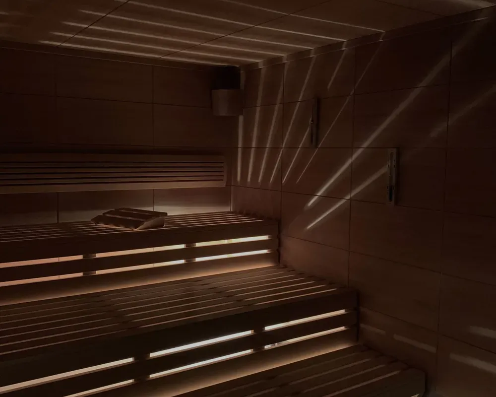 Interior of a Finnish sauna with wooden benches and soft lighting.