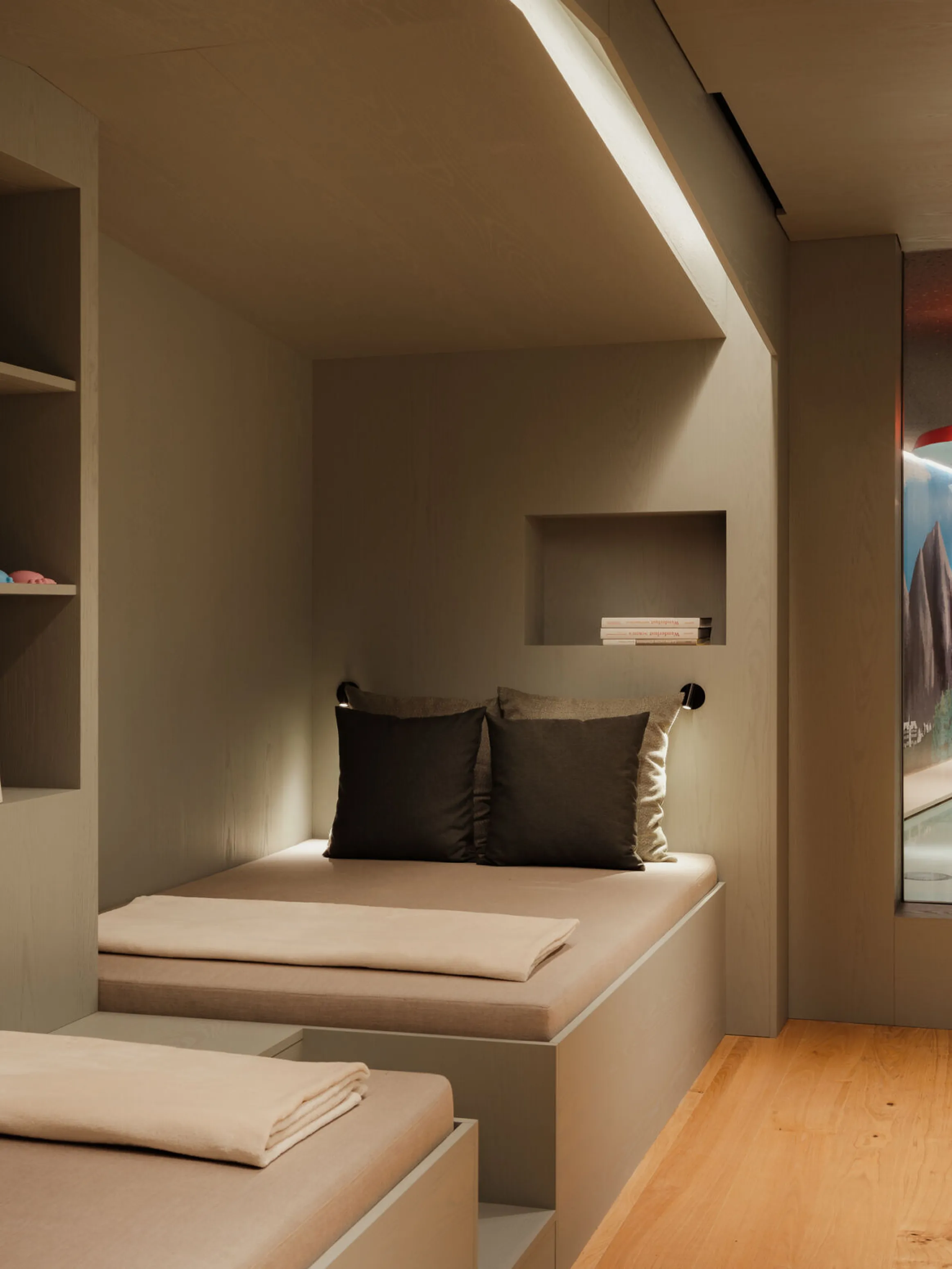 Modern, minimalist interior with built-in seating and neutral tones. A window reveals an indoor pool area, creating a serene and luxurious ambiance.